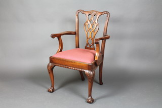A Chippendale style carved mahogany carver chair with pierced vase shaped slat back and upholstered drop in seat, raised on cabriole ball and claw supports
