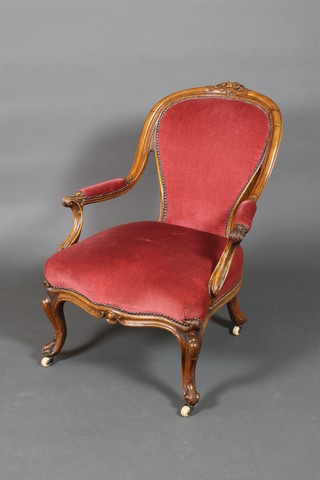 A Victorian bleached mahogany show frame open arm chair with scroll arms and upholstered in pink Dralon, on cabriole supports