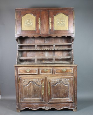 A French 17th/18th Century oak dresser, the raised back with moulded cornice fitted cupboards enclosed by embossed brass doors above a 3 tier plate rack, the base fitted 2 short and 2 long drawers above a double cupboard 89"h x 53"w x 24"d 