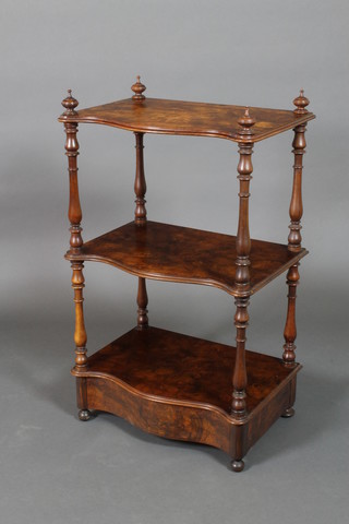 A Victorian figured walnut 3 tier what-not of serpentine outline, raised on turned supports, the base fitted a drawer, on bun feet, 37"h x 22"w x 15"w 