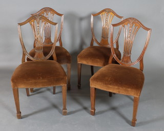 A set of 4 Hepplewhite style mahogany shield back dining chairs with over stuffed seats, raised on square tapered supports ending in spade feet 