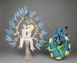 Tessa Fuchs, a Studio ceramic group of a courting couple seated in the bow of a tree 14", a Studio Pottery model of an exotic plant 10" 