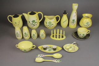 An extensive Carltonware Australian design dinner and coffee service decorated with stylised flowers on a yellow ground, comprising 13 large saucers, 6 large cups, 1 small bowl, a coffee pot, a teapot, a water jug, a vinegar bottle, an oil bottle,  a large pair of salt and peppers, 3 small pairs of salt and peppers, a twin candlestick, a small dish, a large dish, 6 sauce boats, 2 small sauce boats, a dish, teapot, milk jug, 6 small plates, small vase, shallow dish, deep dish, hors d'oeuvres dish, large vase, preserve pot and lid, butter dish lid, candlestick, sugar bowl, 2 egg cups, mustard pot, sauce boat and ladle, 6 coffee cups, 6 saucers, a toast rack, a vegetable dish, a pair of salad servers, a jug, butter knife, 2 mustard spoons, 2 small dishes and a condiment base