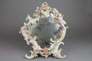 A 19th Century German porcelain Rococo style mirror decorated with cherubs, flowers and scrolls, shaped bevelled plate 17" (f) 