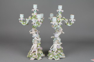 A pair of 19th Century German porcelain 4 light candelabra decorated with cherubs and flowers on raised Rococo bases 16" (f)