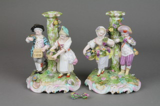 A pair of 19th Century German porcelain candlesticks decorated with figures and birds on raised Rococo bases 7" (f) 