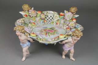 A 19th Century German porcelain centre piece, the pierced dish supported by cherubs encrusted with flowers 14" (f)