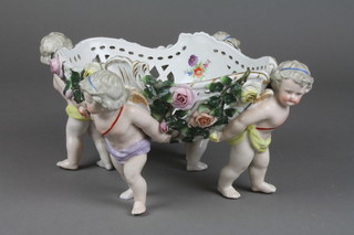 A 19th Century German porcelain centre piece the oval bowl supported by cherubs with encrusted floral decoration 13" (f)