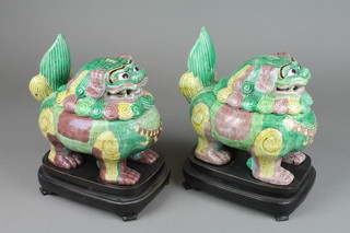 A pair of 18th Century style Shi Shi dogs pots and covers decorated in the archaistic style on hardwood bases 10" 