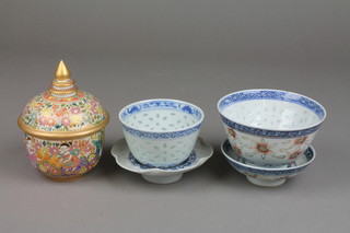 A Chinese rice decorated teabowl and cover, a similar ditto and a lidded pot 