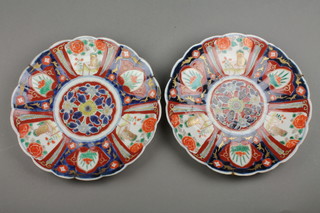 A pair of late 19th Century scalloped Imari dishes with panels of dogs amongst flowers with a formal floral centre 10" (f)