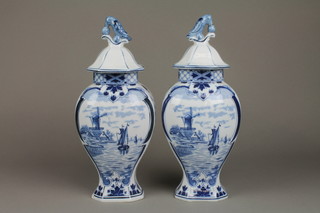 A pair of Delft baluster vases and covers with Dutch canal scenes and stylised bird finials 13"