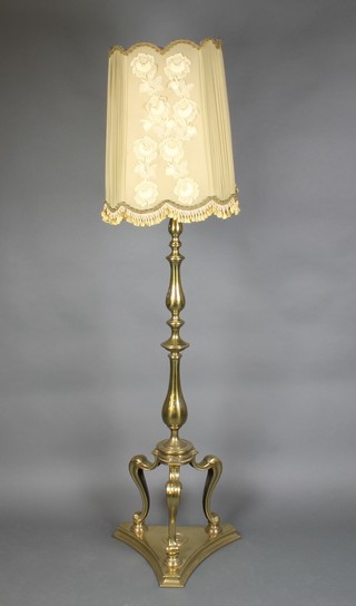 A gilt metal standard lamp, raised on cabriole supports with triform base 56"