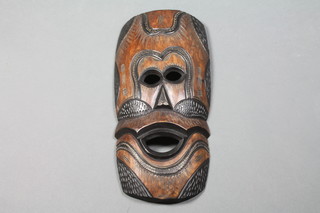A carved Eastern wooden mask 19" x 10" 