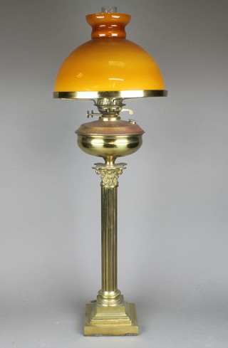 A Victorian style brass oil lamp with amber glass shade and clear glass chimney, raised on a brassed reeded Corinthian column 35"h 