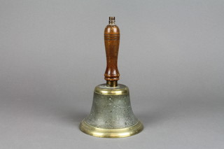 A brass bell with turned oak handle