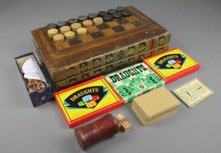 A Victorian games compendium in the form of 2 leather bound books with chessboard, backgammon board and contents of various draughts, other games etc 