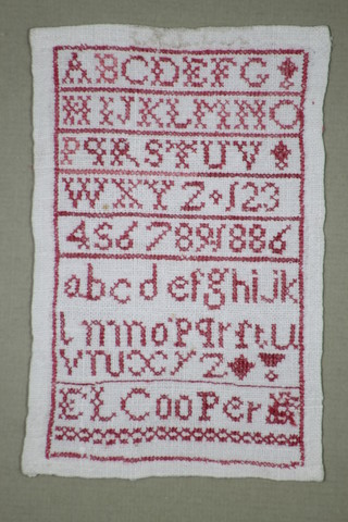 L F Cooper, a woolwork sampler with alphabet and letters 5" x 3" contained in a maple frame together with a 1975 Continental woolwork sampler with motto 35" x 7" 