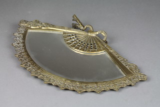 A bevelled plate fan shaped mirror contained in a pierced brass frame 9" x 15" 