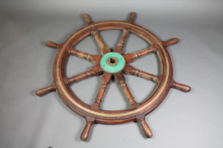 A wooden and brass banded 8 spoked ships wheel 53" diam. the boss marked 9068