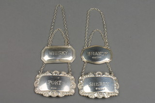 A pair of repousse silver spirit labels and 2 others 