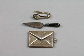 A silver tie clip, an envelope stamp case and trowel book mark