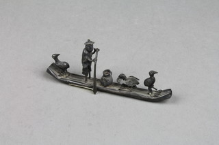 A Chinese white metal model of a figure on a raft with 3 birds and a pot, 4"