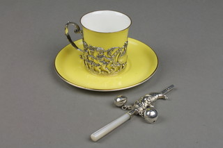 A coffee can and saucer with repousse silver mounts and a ditto mother of pearl babies teether, whistle, rattle