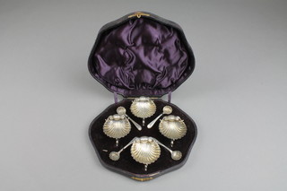 A cased set of 4 Victorian silver shell table salts with dolphin feet, London 1892 with 4 matching shell bowl spoons, Birmingham 1892