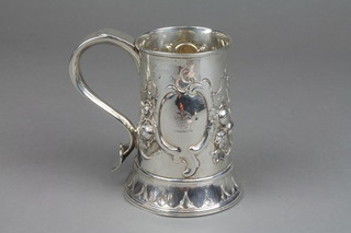 Peter, Ann and William Bateman.  A Georgian repousse mug decorated with panels of flowers and revellers in an interior scene, the cartouche with chased armorial with S scroll handle 5" 