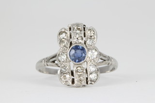 An 18ct Art Deco style ring, set with a centre stone brilliant cut sapphire surrounded by brilliant cut diamonds