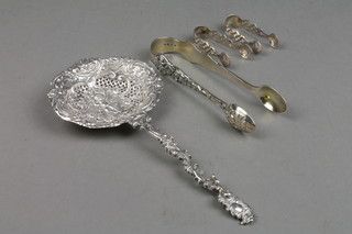 A pair of Victorian silver sugar nips decorated with classical figures and masks, London 1871, a pair of shell bowl nips and a Continental caster spoon with pierced decoration 