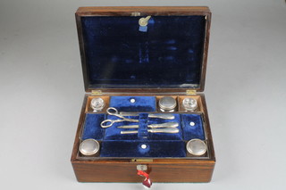A Victorian rosewood toilet box containing plated mounted bottles and a silver mounted manicure set