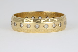 An 18ct gold gem set wedding band, approx. 6 grams