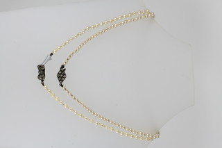 A string of cultured pearls with a silver clasp 20" and an imitation string of pearls