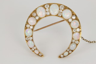 A fine mid Victorian gold, diamond and opal crescent brooch, set with 11 circular and oval cut opals, interspersed with 24 brilliant cut diamonds in a fitted box 