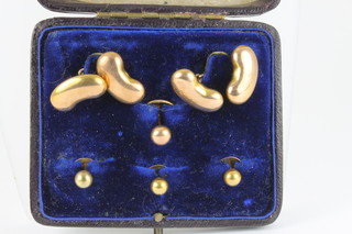 An Edwardian 9ct gold cufflink and stud set, the cufflinks in the form of beans 