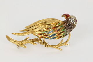 A good 18ct yellow gold brooch in the form of a parrot sitting on a branch decorated in coloured enamels and diamonds with a ruby set eye, approx. 12 grams