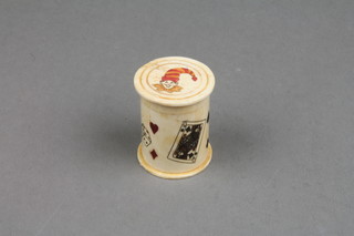 A modern carved bone cylindrical box containing a set of dice