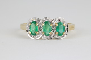 A 14ct yellow gold triple emerald and diamond cluster ring