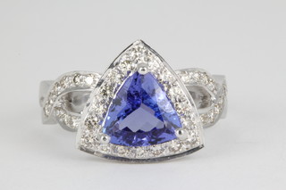 A 14ct white gold tanzanite and diamond cluster ring, the triangular cut tanzanite approx. 2.05ct surrounded by 18 brilliant cut diamonds on an open shank with diamond chips approx 1.0ct