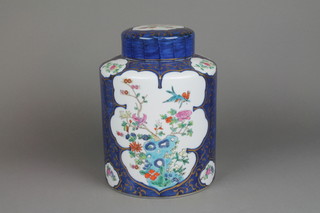 A modern Sampson style cylindrical ginger jar and cover with dark blue ground decorated with panels of birds amongst flowers