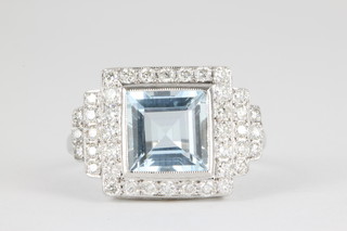 An 18ct white gold aquamarine and diamond cluster ring, the princess cut aquamarine approx. 2ct surrounded by 40 brilliant cut diamonds in a stepped mount