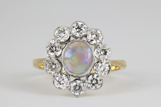 An 18ct yellow gold opal and diamond cluster ring, the centre opal approx. 0.7ct surrounded by 10 brilliant cut diamonds 