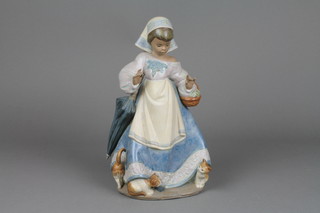A Lladro tan glazed figure of a young lady with kittens beneath her dress 12"
