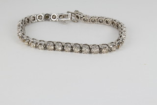 A 14ct, 23 stone diamond tennis bracelet with claw mounts, approx. 7.5ct