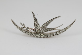A Victorian diamond set brooch in the form of a dove with olive branch astride a crescent moon with ruby set eye
