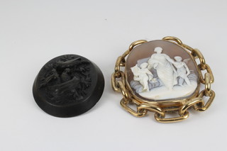 A Victorian gold plated cameo brooch with classical figures in an entwined mount and a carved jet brooch