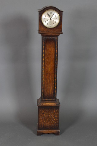 A 1930's 8 day striking "Granddaughter" clock, the 6 1/2" dial with Arabic numerals contained in an oak arch shaped case 54 1/2"