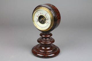An aneroid barometer with enamelled dial contained in a turned granite case 8" 